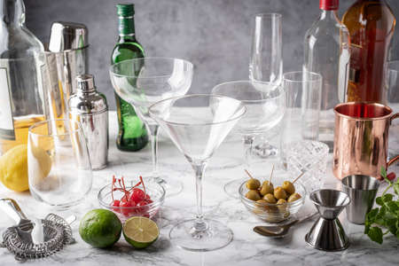 cocktail glasses and utensils on marble tableの写真素材