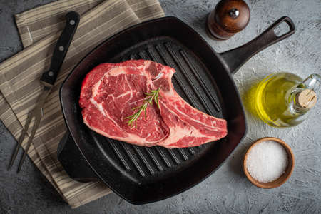 raw ribeye steak on cast iron panの写真素材