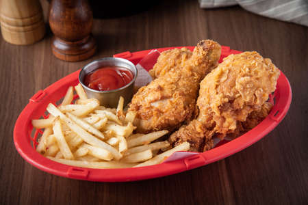 fried chicken with french fries in plastic basketの写真素材