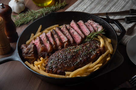sirloin steak with french fries in iron skillet panの写真素材