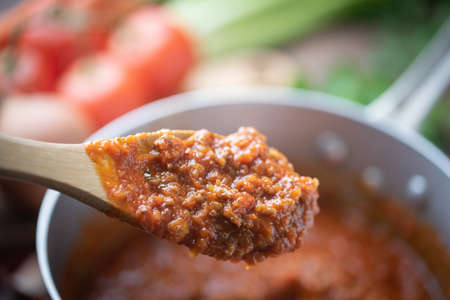bolognaise sauce in pot with ingredients background