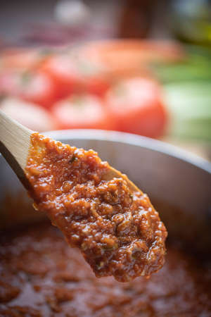 bolognaise sauce in pot with ingredients backgroundの写真素材