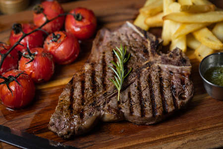 T-bone steak with baked tomato and french fries