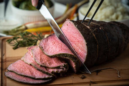carving roast beef with knife and fork