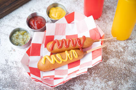 corn dog with ketchup and yellow mustardの写真素材