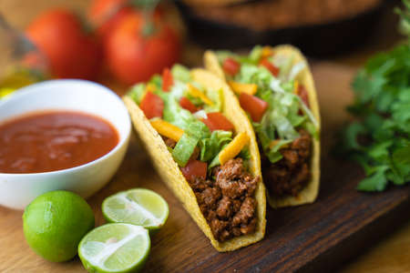 hard shell taco on wooden board with lime