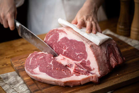 chef cutting block of ribeye beef steakの写真素材