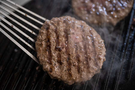 cooking beef patties on grillの写真素材