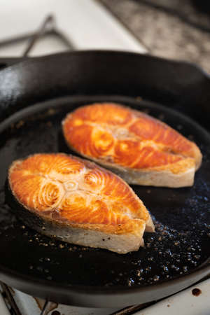 grilling salmon fillet steak on iron skillet panの写真素材