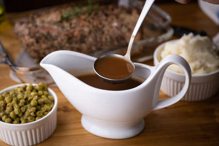 gravy sauce in sauce pod with mashed potatoの写真素材