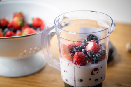 pouring milk into the blender for berry smoothie