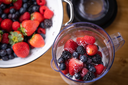 pouring milk into the blender for berry smoothie