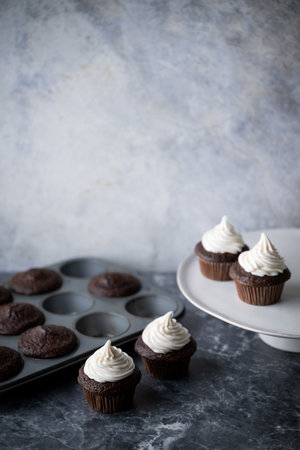 chocolate cupcake with white icing on dark backgroundの写真素材