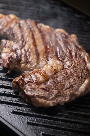 ribeye steak on hot smokey grillの写真素材