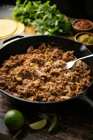 carnitas in skillet pan with tacos ingredientsの写真素材