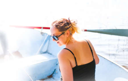 Happy young woman in a boat goes fishing.の写真素材