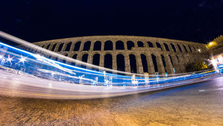 A bus drives through the shot of the famous Segovia Aqueduct.の写真素材