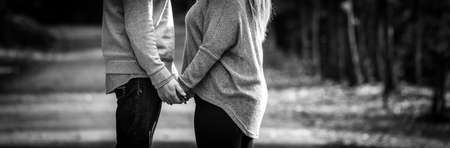 Young couple facing each other, torso level view, holding hands, black and white, expressing love,A...