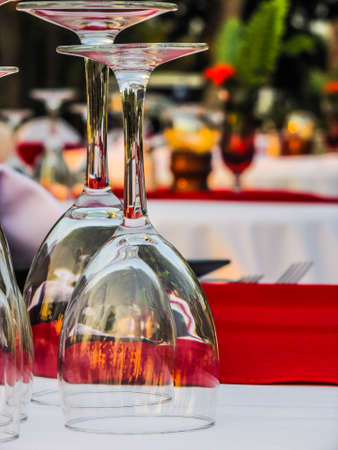 Cocktail glasses for two.  Evening dinner tables alfresco.  Resort table set for two with upside down wine glasses on a dinner table outside on a beach in El Salvador.の写真素材