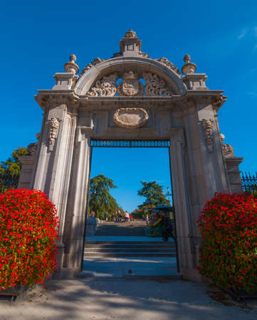 Gates to Retiro Park of Madrid, Spain on a blue-sky sunny day.  Citizens of Madrid and tourists alike enjoy a fabulous warm November day in one of the main parks.の写真素材