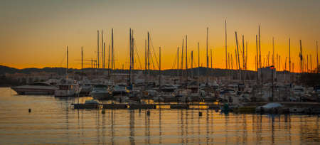 Evening dramatic colorful sunset in the port of St Antoni de Portmany, Ibiza, Balearic Islands, Spain.  Boats in marina at the end of a warm sunny day in Ibiza, Spain.の写真素材