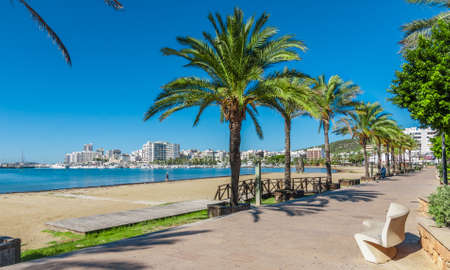 Mid morning sun, walk along the beach near the city.  Warm sunny day along the water's edge in...