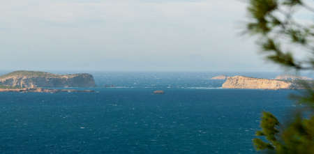 Panoramic hill side view from St Antoni de Portmany, Ibiza, into balearic sea on a clearing day in November, featuring the oft viewed Conejera islands.の写真素材