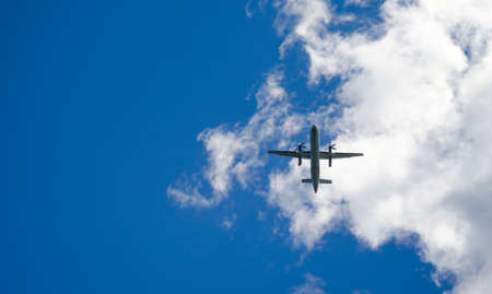 Blue sky fly-over.   Aircraft on a glide path to the airport in St John's Newfoundland, Canada.   An airplane passes overhead in sunny blue sky weather landing at the airport in St. John's, Newfoundland.の写真素材