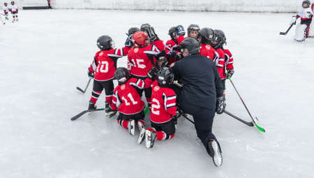 Team spirit - hockey coach gets the spirits of a very young team, up before they start the game.のeditorial素材