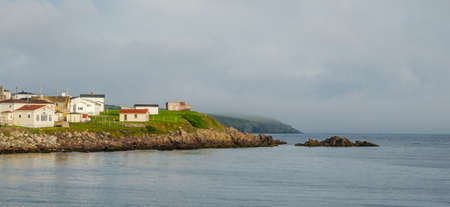 Sun comes up on small town Newfoundland.   Sleepy Grand Bank village emerges from morning fog in...