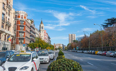 Postcards from Spain.  Taxis in traffic wait for the light on Alica street in the City of Madrid, Spain.   Autumn urban life with street traffic.のeditorial素材