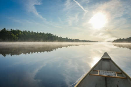 Canoe trip in the morning.  Brilliant and bright mid-summer sunshine morning, paddling a canoe in the middle of quiet, calm and peaceful Corry lake.の写真素材