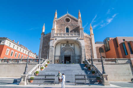 Madrid, Spain, November 9th, 2013:   Tourism in Spain.  Warm November day sees faithful people emerging from church & coming down steps outside.   Steps lead to   beautiful stone & masonry cathedral.のeditorial素材
