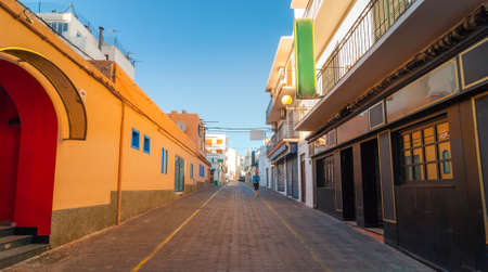 Glowing Warm tones from indirect afternoon sun.  Man walks down the road in the streets of St Antoni de Portmany, Ibiza, Balearic Islands, Spain.のeditorial素材
