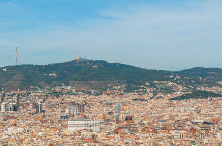 Barcelona cityscape view from high a level, cable car as it passes over tree tops providing views of the city.の写真素材