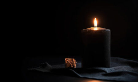Burning candle on a black background with copy space for text.の素材