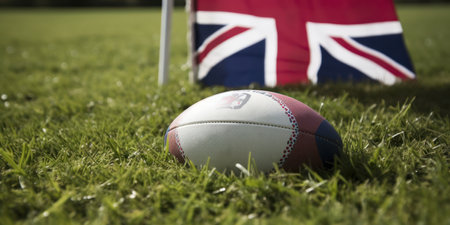 Close-up of rugby ball on field with Union Jack flag in backgroundの素材