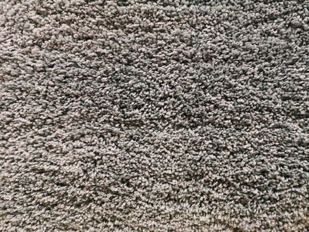 dense and crumpled texture of a carpet with gray color with light shades.