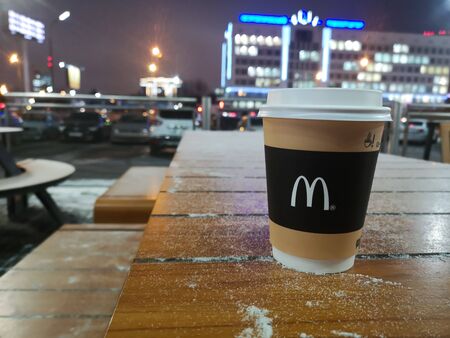 Glass of coffee with logo McDonald s in winter in summer cafe on the background of night city on January 15, 2020 in Russia, Kazan, Mullanura Vakhitova Street 1のeditorial素材