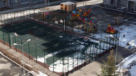 Empty sports basketball and football ground and deserted children s playground in the yard of a...