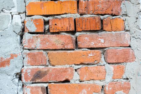 Texture of an old orange brick wall with cracks. Background of red clay brick with cracks with...