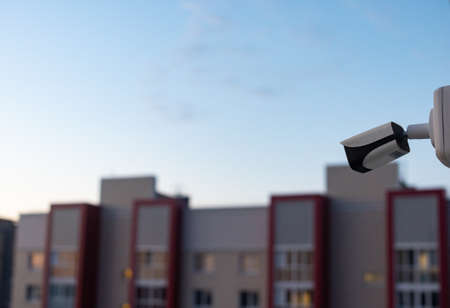 CCTV camera on the roof of a multi-level parking lot with a residential building in the background...