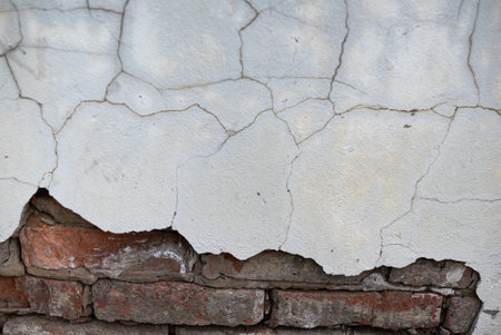 old brickwork and cracked collapsed plaster on an ancient wall