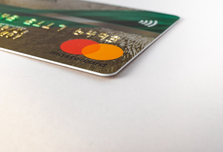 bank card with the logo of the international payment system MasterCard Incorporated close-up on a white isolate 11.14.2020 in Russia, Kazan, Spartakovskaya street 88bのeditorial素材