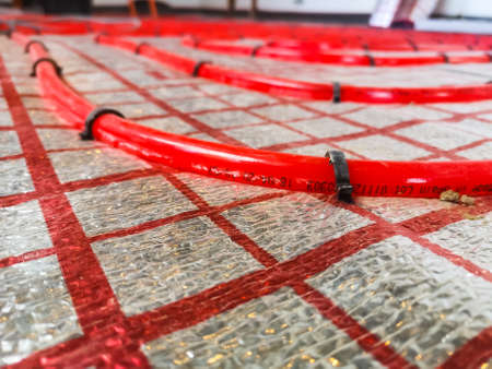 cross-linked polyethylene heating pipes for water heating of a warm floor in a private house are installed on an insulating material.の写真素材