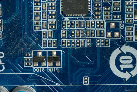 several board microcircuits and transistors on the motherboard in a dusty personal computer...