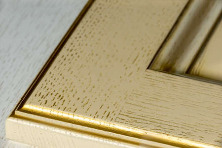 corner of a textured white classic kitchen facade with gilding and texture close-up. background for...