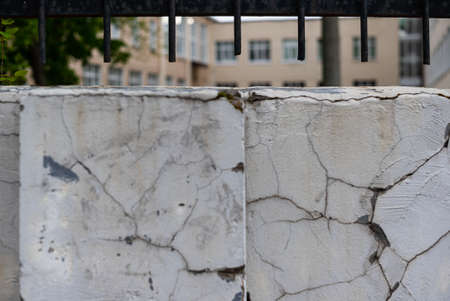 textured cracked plaster on the wall with a metal fence.