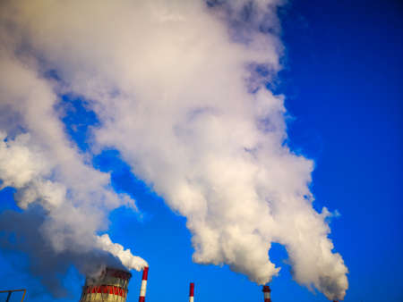 chimneys of a thermal power plant in the city smoke, polluting the environment.の写真素材