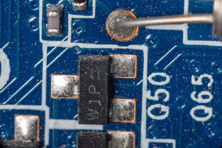 several microcircuits on a motherboard in a dusty personal computer close-up